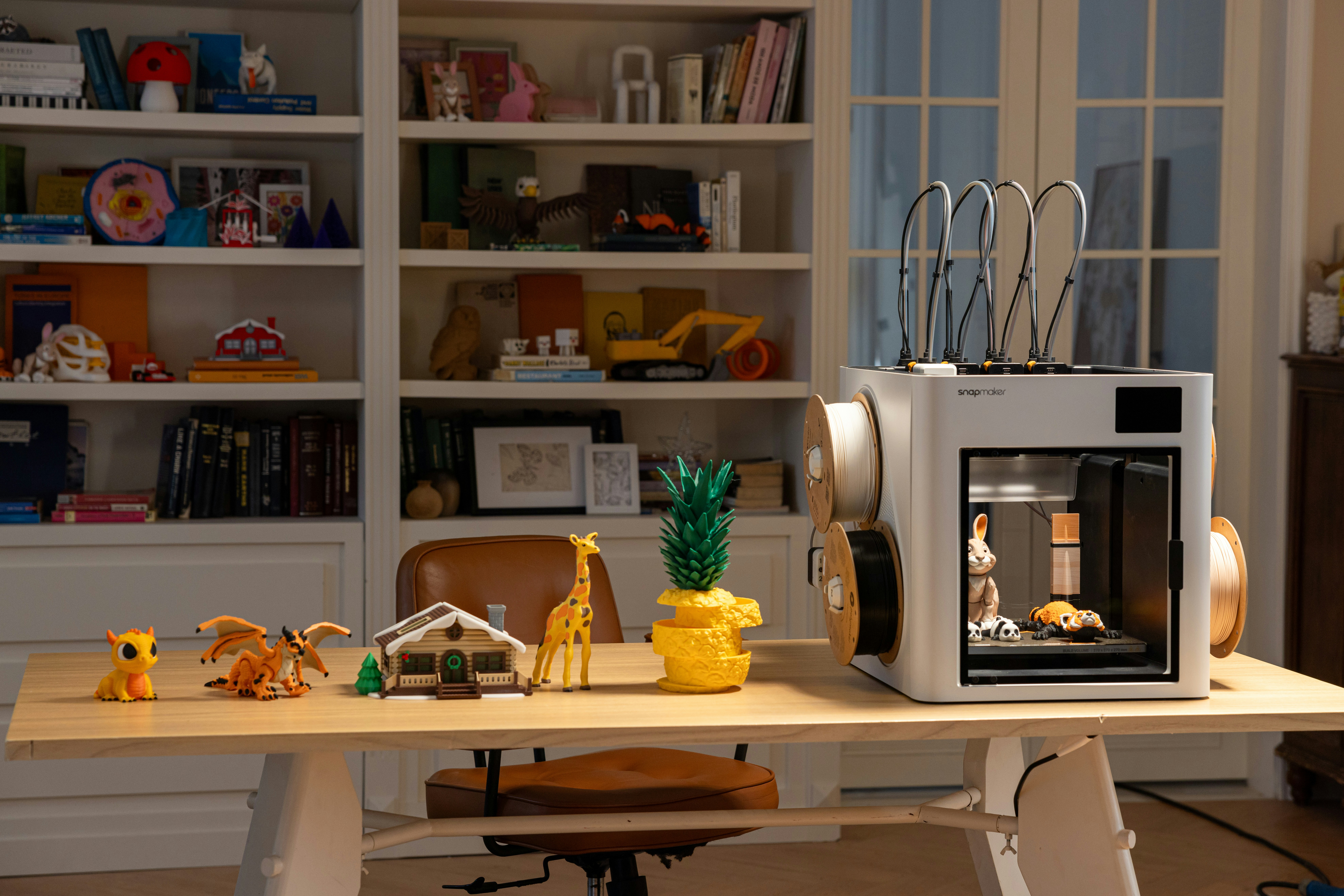 Snapmaker 3D printer with toys and books on shelf — photo by Snapmaker 3D Printer on Unsplash